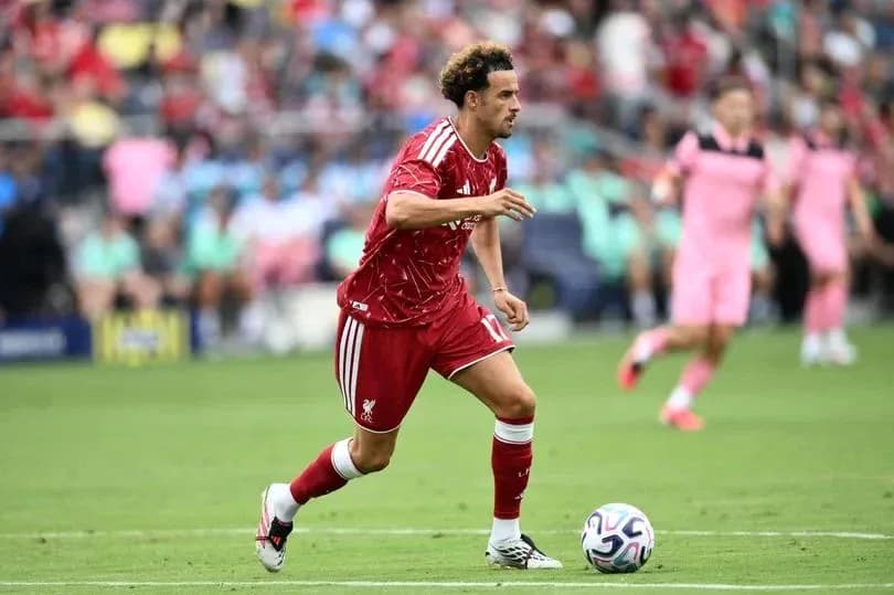 Jugador de Liverpool corriendo con el balón en campo