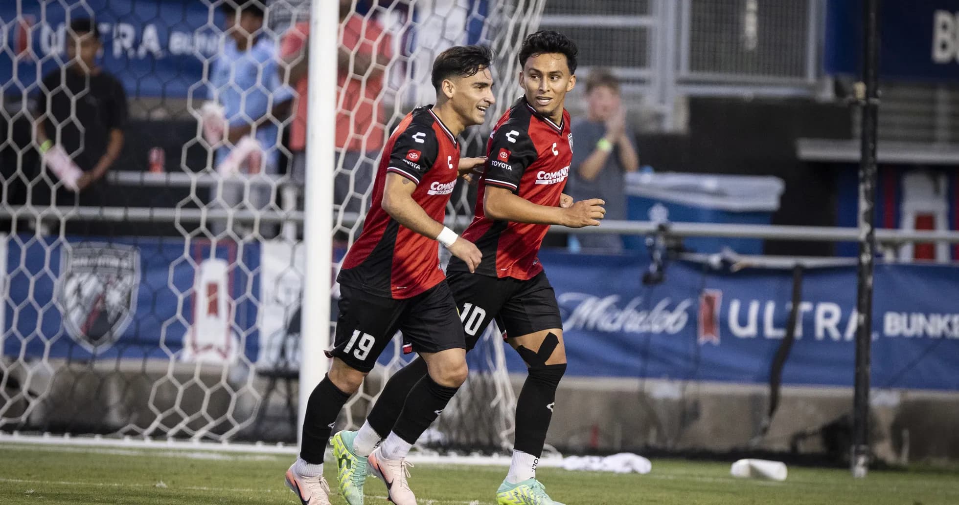 Dos jugadores celebrando un gol en el partido