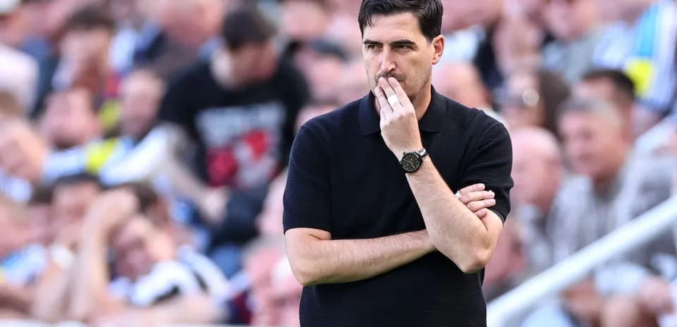 Entrenador observando el partido con los brazos cruzados