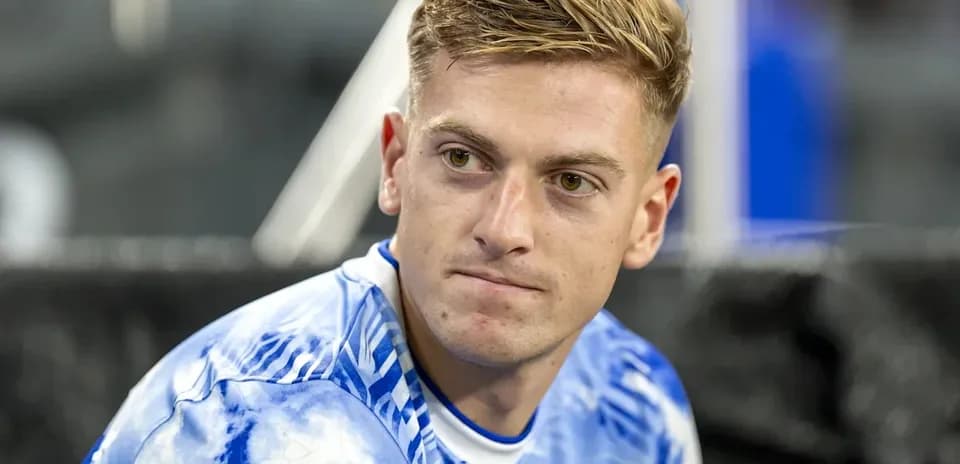 Jugador sentado en el banco con camiseta azul
