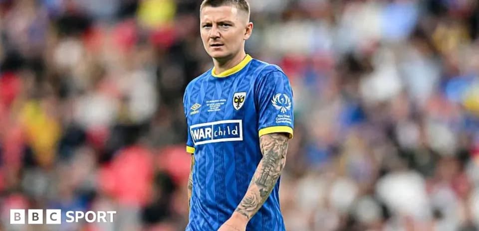 Jugador de fútbol con camiseta azul en el campo