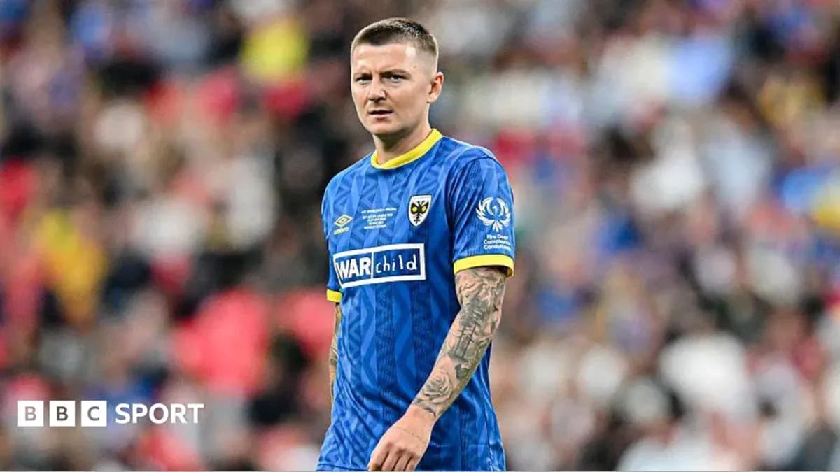 Jugador de fútbol con camiseta azul en el campo