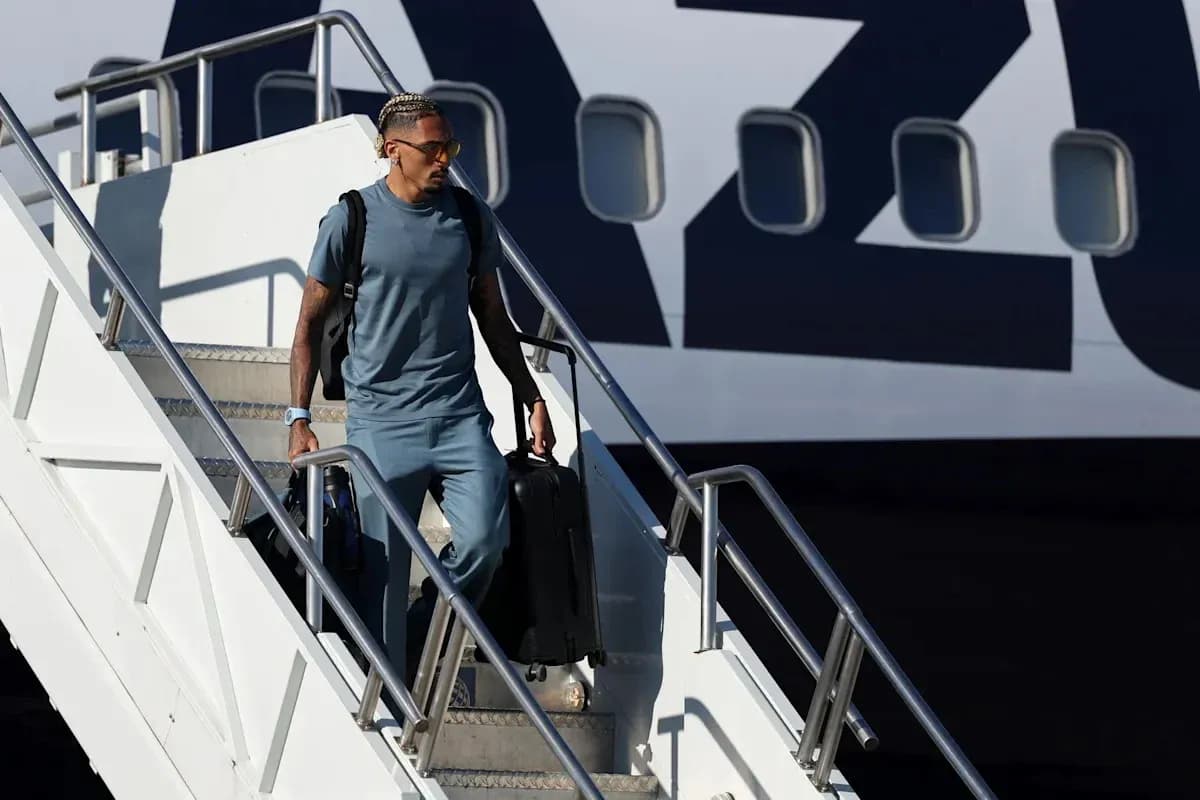 Jugador bajando del avión con maleta