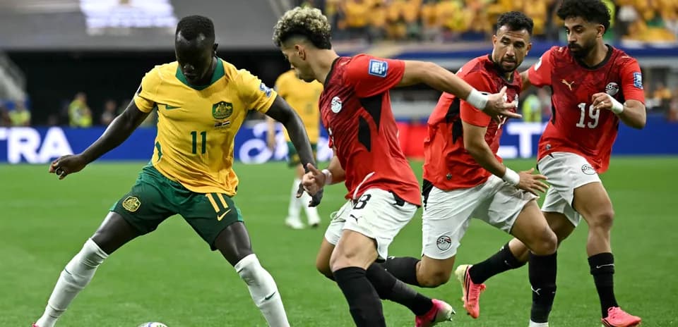 Jugador de Australia driblando a defensores egipcios en partido