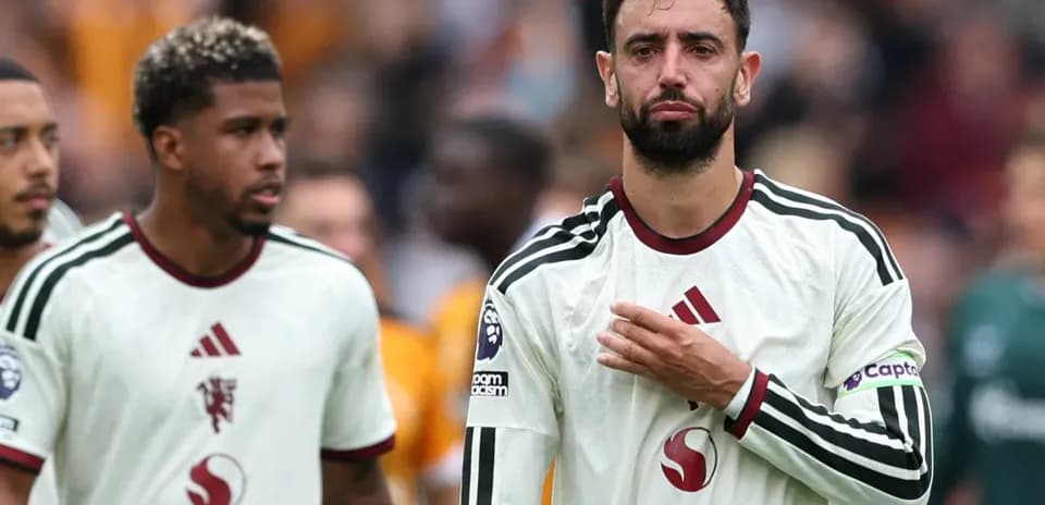 Jugadores de pie tras el partido con camisetas blancas