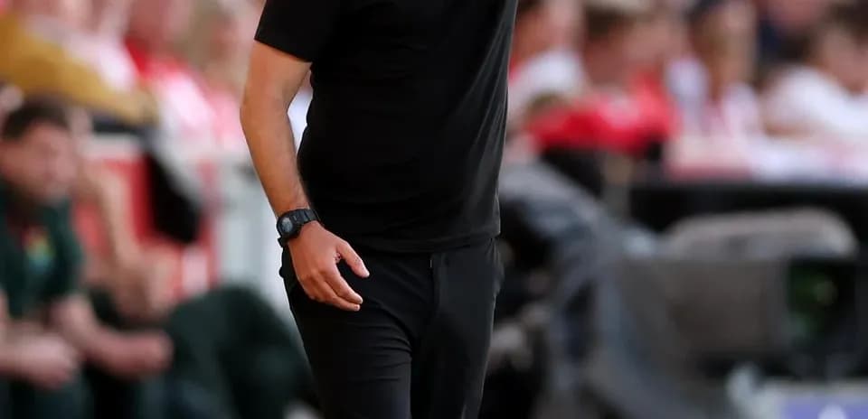 Entrenador dirigiendo desde la línea de banda