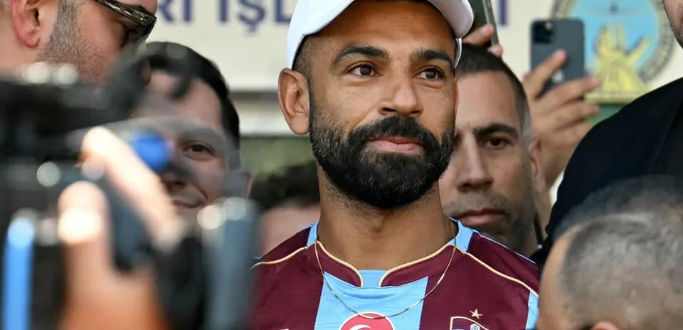 Jugador en camiseta de Trabzonspor rodeado de personas