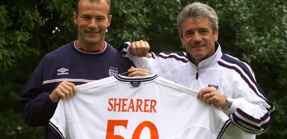 Alan Shearer y entrenador mostrando camiseta con número 50