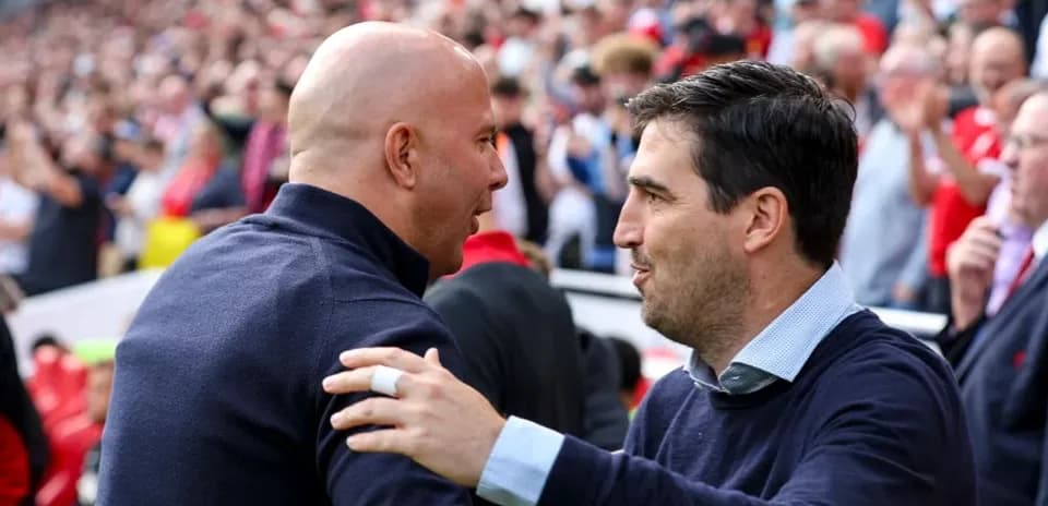Entrenadores saludándose en el estadio durante partido
