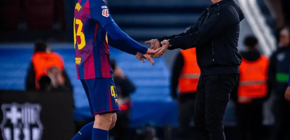 Jugador y entrenador saludándose en el campo