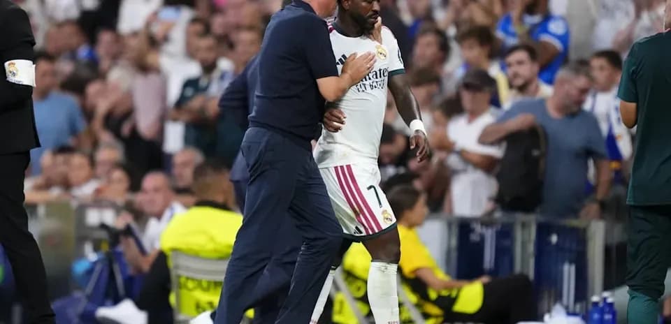 Entrenador saludando a jugador de Real Madrid en el banquillo