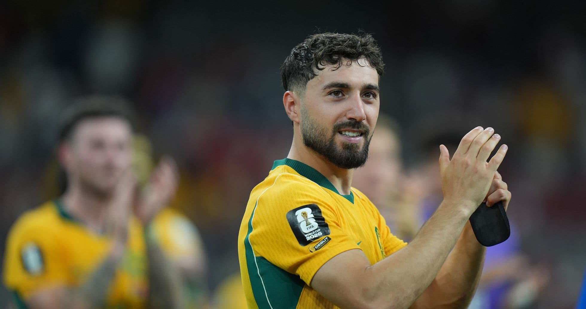 Jugador aplaudiendo en camiseta amarilla de Australia