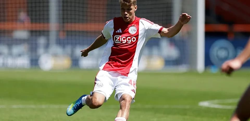 Jugador de Ajax pateando el balón en el campo