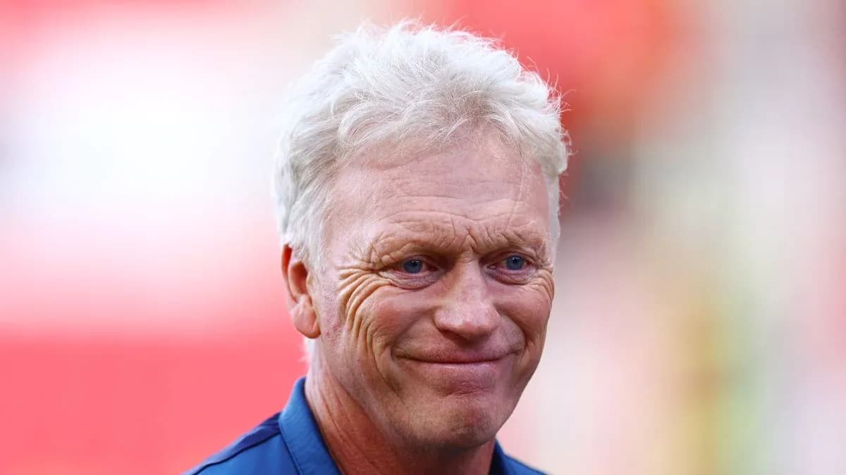 Entrenador sonriendo en el campo de fútbol