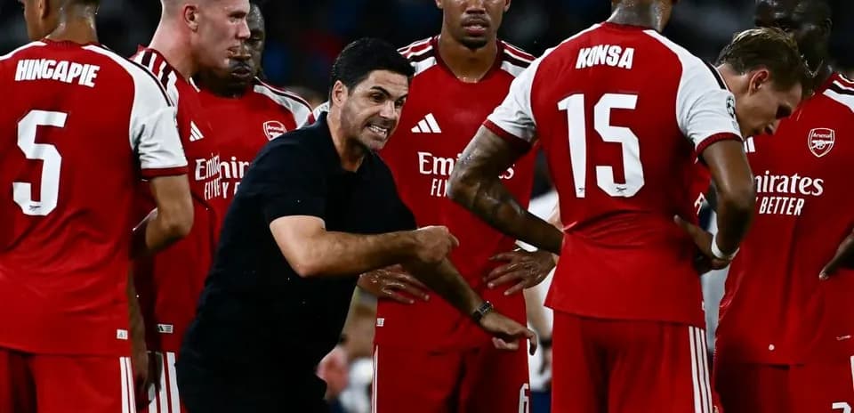 Entrenador dirigiendo a jugadores de Arsenal en reunión
