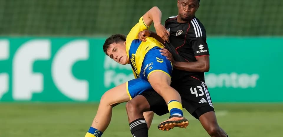 Jugador intentando recuperar el balón en el suelo