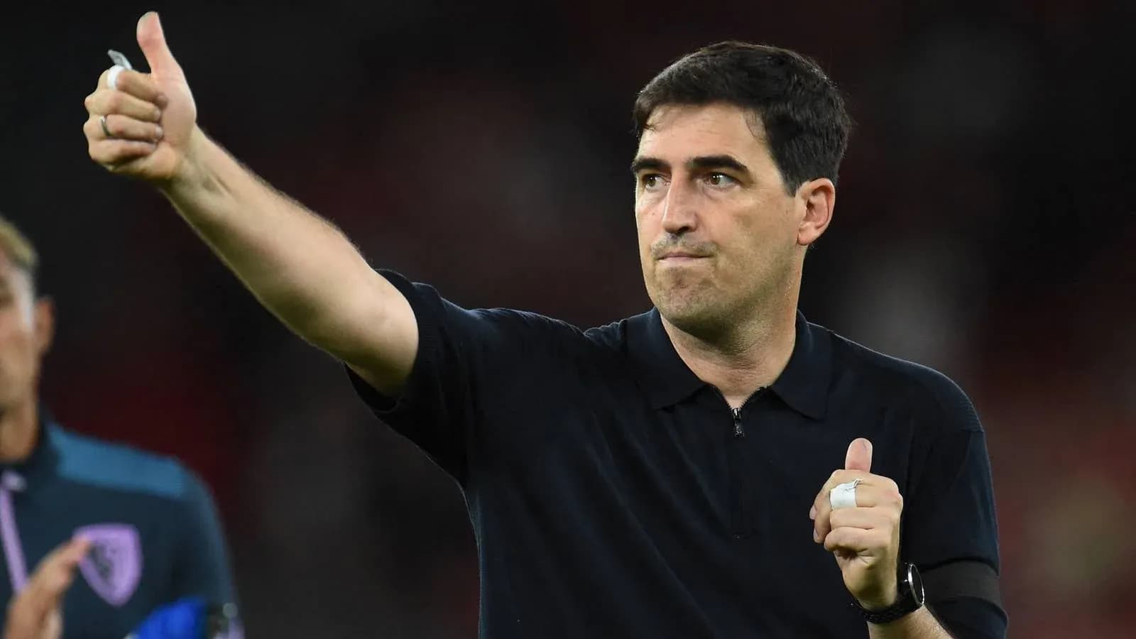Entrenador dando señal de aprobación en el partido