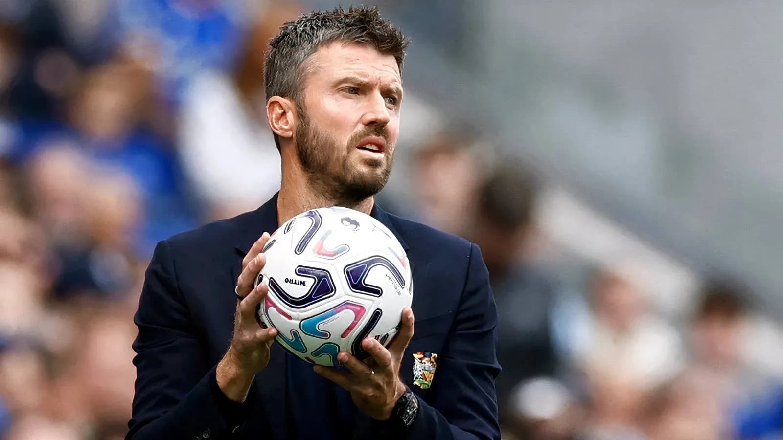 Entrenador sosteniendo un balón durante el partido