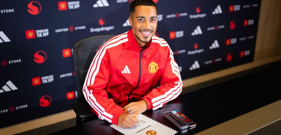 Jugador de Manchester United firmando contrato en mesa