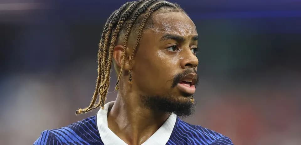 Jugador de fútbol con trenzas en campo de juego