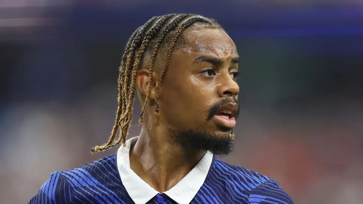 Jugador de fútbol con trenzas en campo de juego