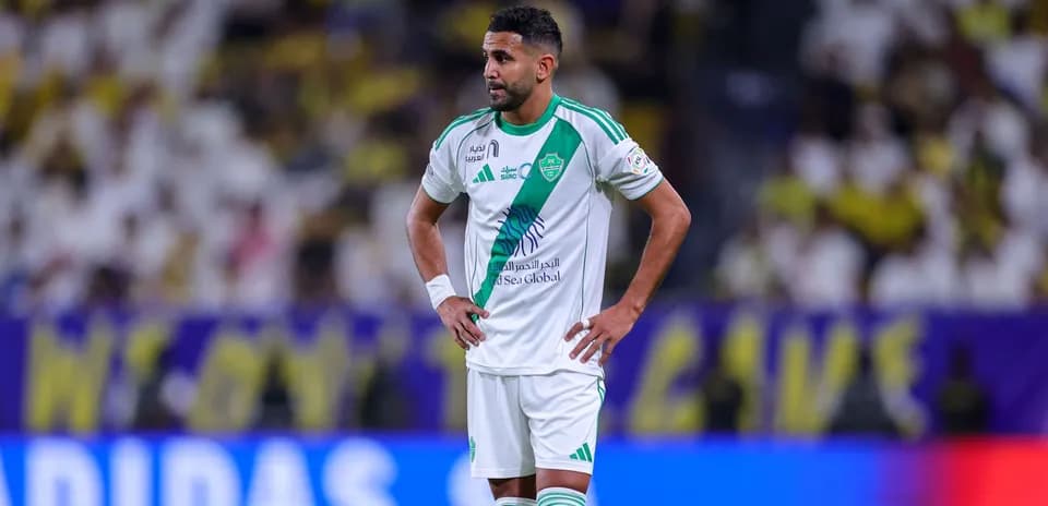 Jugador de fútbol con camiseta blanca y verde en el campo