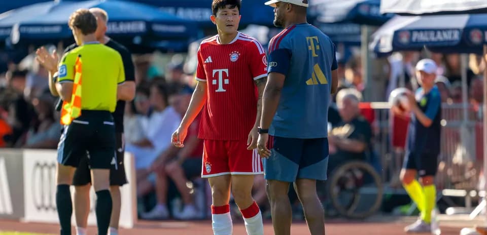 Jugador de Bayern hablando con entrenador en el campo