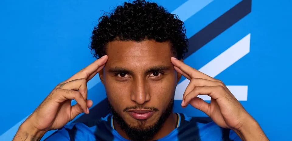Jugador haciendo gesto con las manos frente a fondo azul