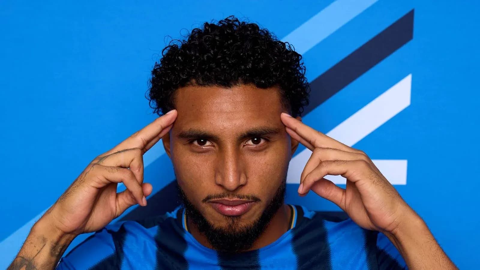 Jugador haciendo gesto con las manos frente a fondo azul