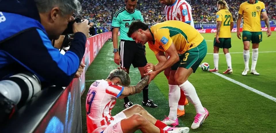 Jugador caído siendo atendido por compañeros y árbitro