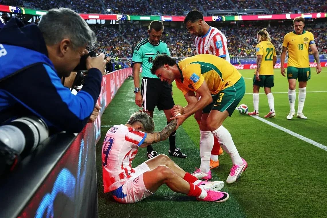 Jugador caído siendo atendido por compañeros y árbitro