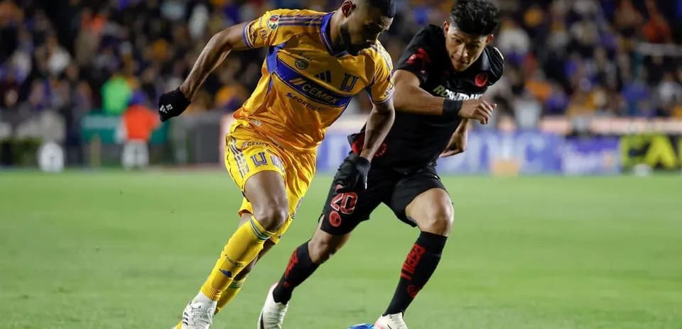 Jugador de Tigres UANL driblando a jugador de Toluca
