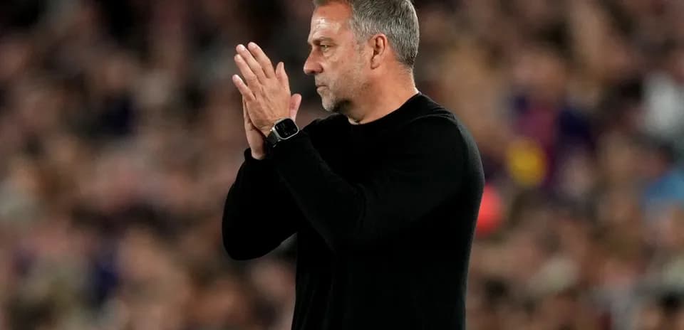 Entrenador aplaudiendo en el banquillo durante partido