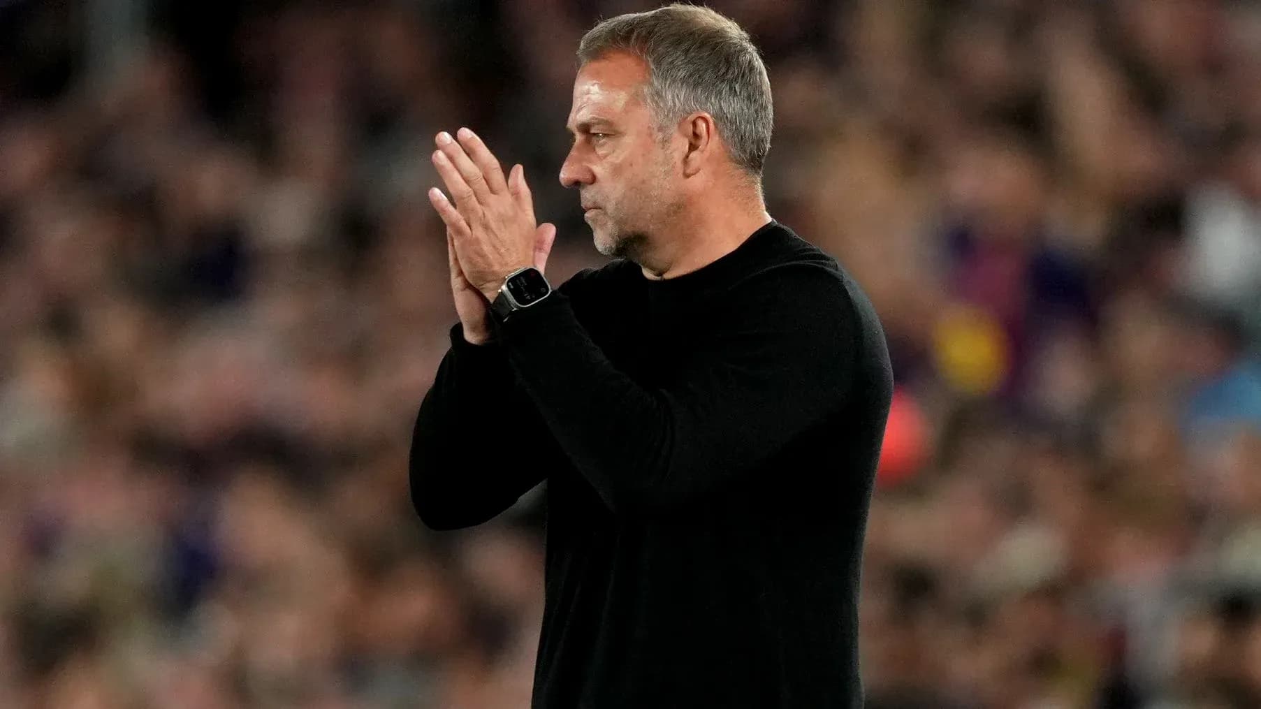 Entrenador aplaudiendo en el banquillo durante partido