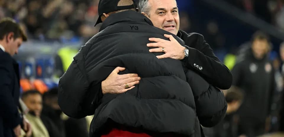 Entrenadores abrazándose en el banquillo durante el partido