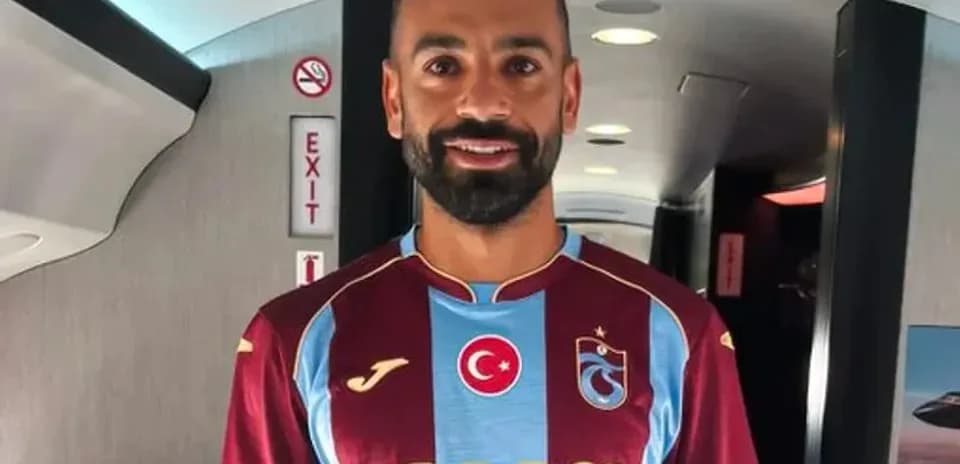 Jugador posando con camiseta de Trabzonspor en avión