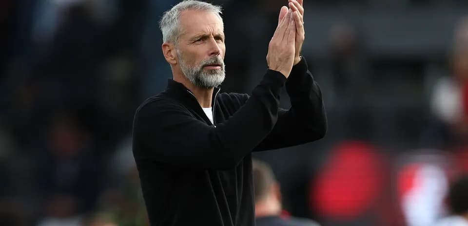 Entrenador aplaudiendo a los aficionados en el estadio