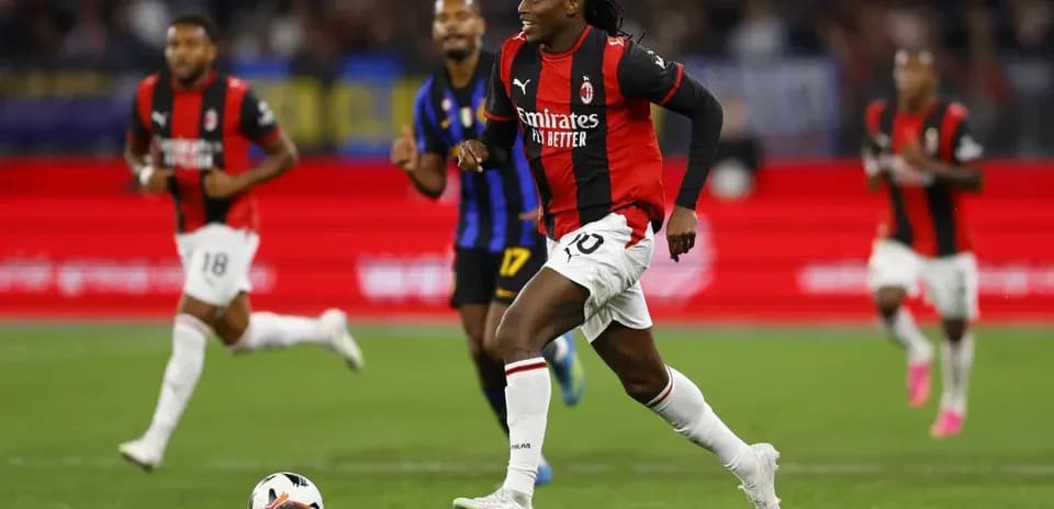 Jugador del AC Milan corriendo con el balón en el campo