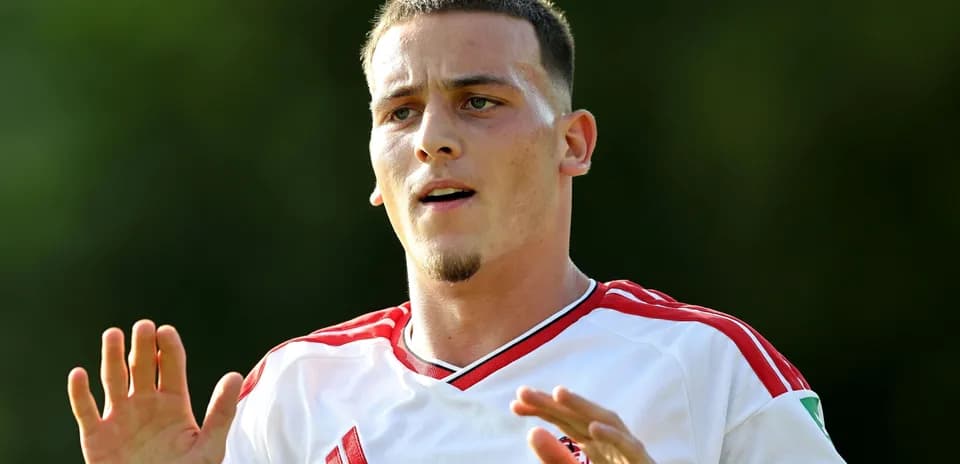 Jugador en acción con camiseta blanca y roja