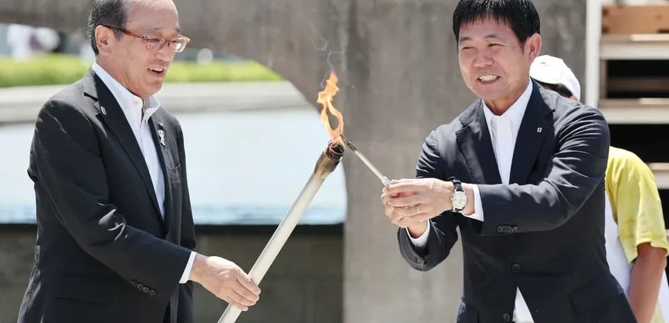 Dos personas encendiendo una antorcha en evento