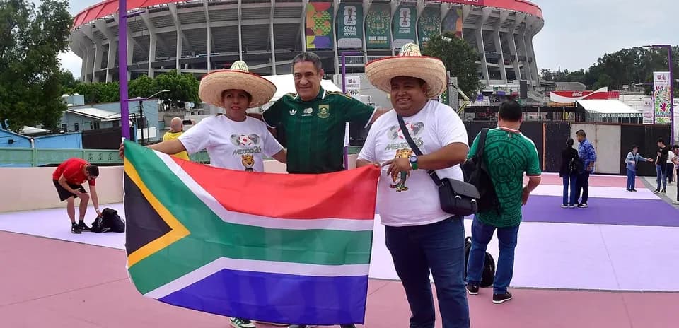 Aficionados sosteniendo bandera sudafricana en el estadio
