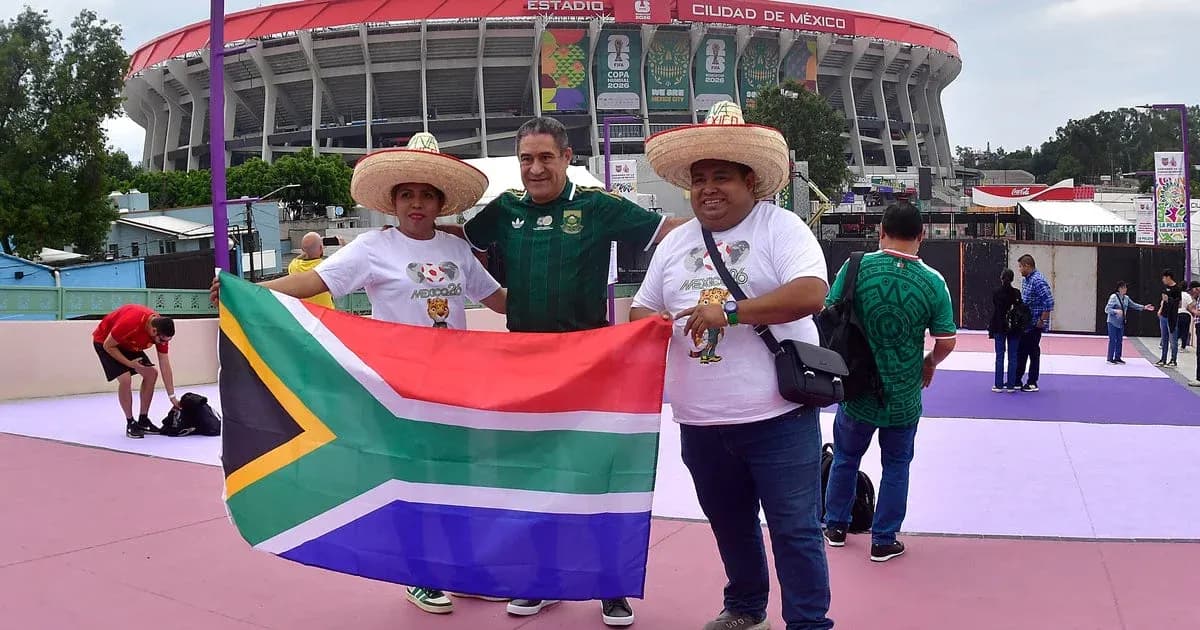 Aficionados sosteniendo bandera sudafricana en el estadio