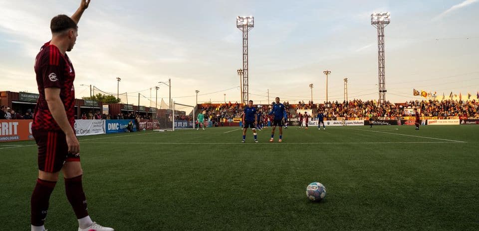 Jugador señalando en partido de fútbol