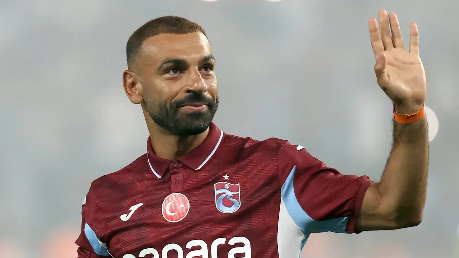 Jugador saludando con la mano en el campo
