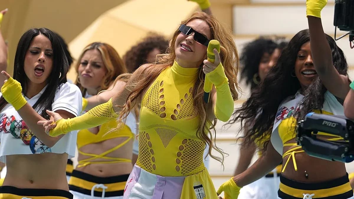 Artista en actuación con bailarinas en escenario