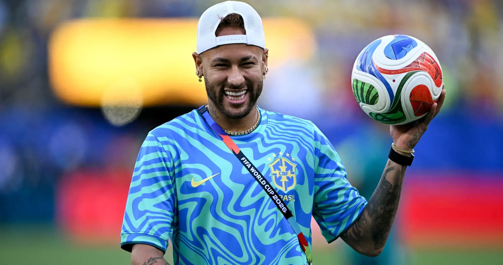 Neymar sosteniendo un balón en el campo de fútbol