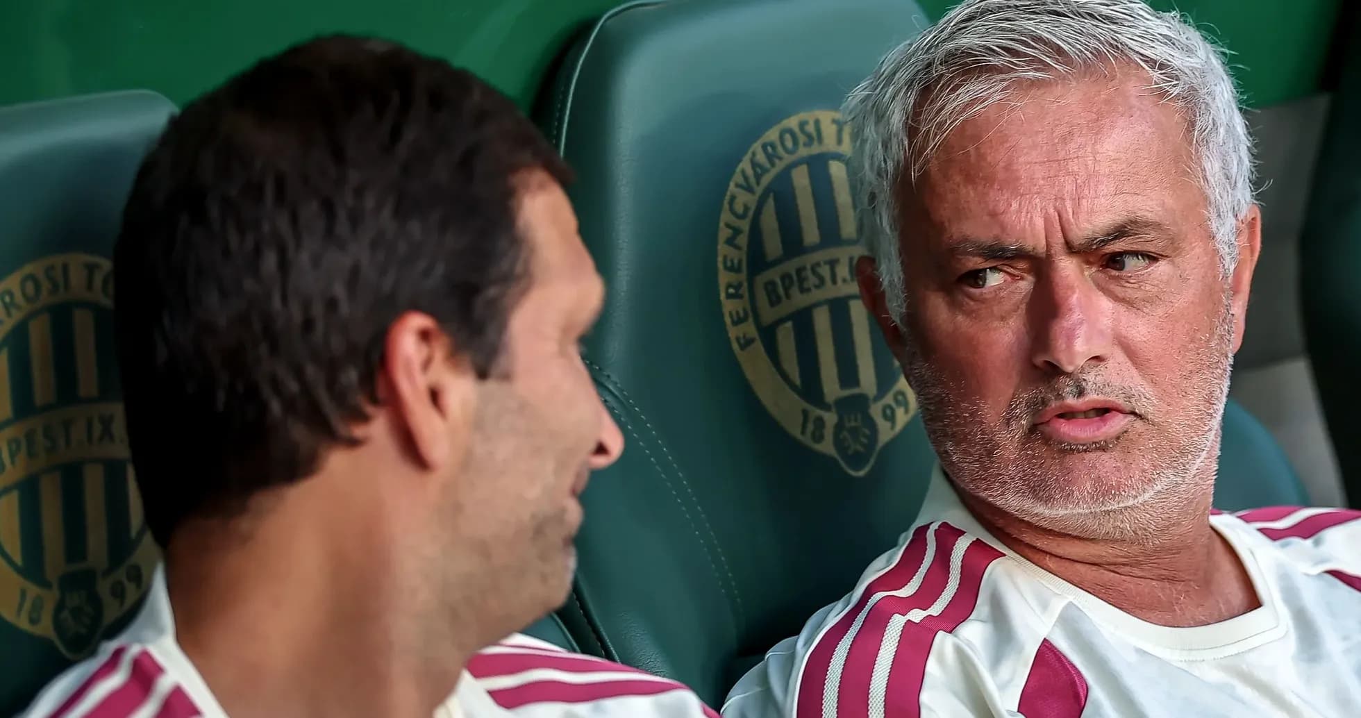 Entrenador y jugador conversando en el banquillo