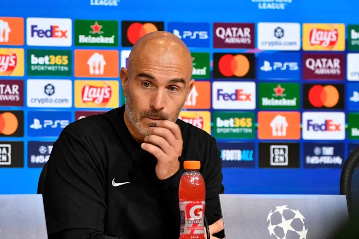 Entrenador en conferencia de prensa con patrocinadores detrás