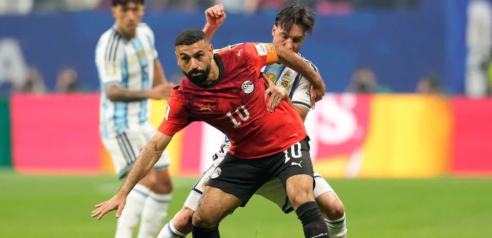 Jugador egipcio luchando por el balón contra argentino