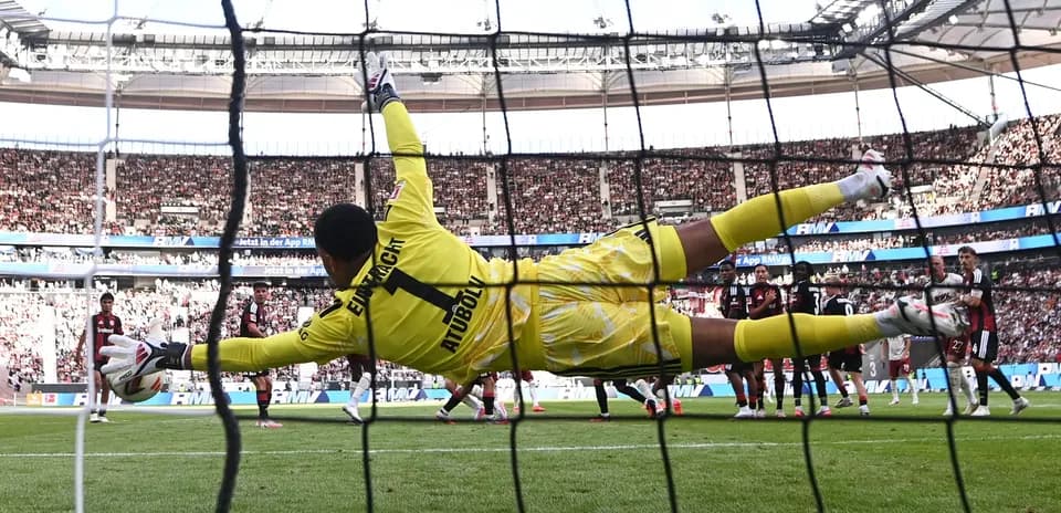 Portero saltando para detener un penalti en el estadio